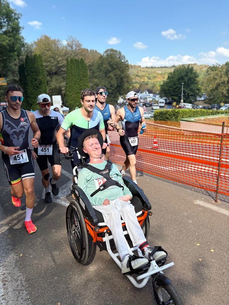 Nous poussons Val en fauteuil de course pendant le triathlon